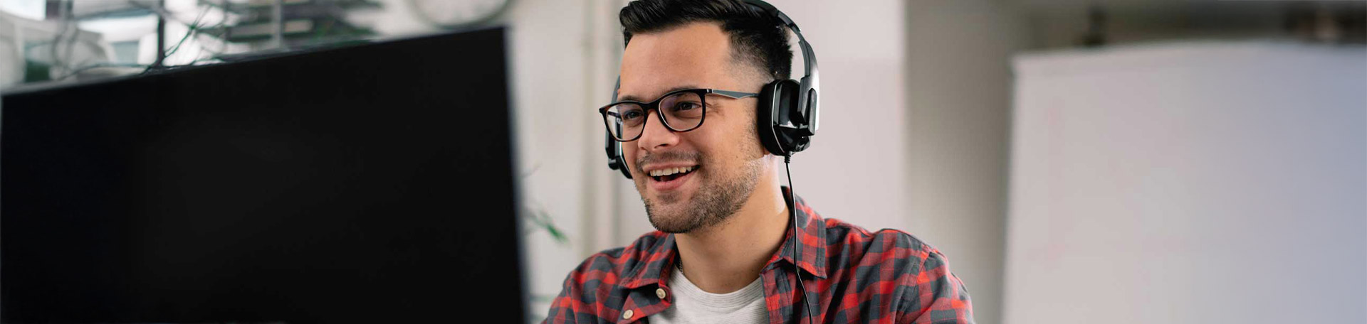 Mann mit Headset blickt auf Bildschirm